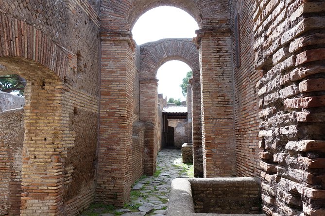 Ancient Ostia Antica Semi-Private Day Trip from Rome by Train with Guide - Baths of Neptune and the amphitheater, two stops built for spectacle